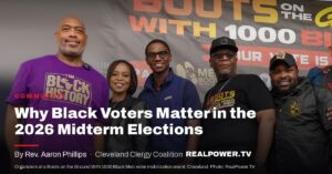 Organizers standing under a Boots on the Ground With 1000 Black Men banner reading Your Vote Is Your Voice, at a Cleveland voter mobilization event.