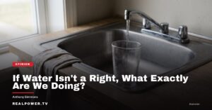 A kitchen faucet running water into a clear drinking glass in a modest kitchen.